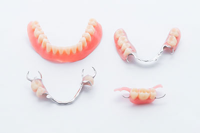 The image shows a set of dentures with teeth on the top row and a bottom row without teeth, displayed against a white background.