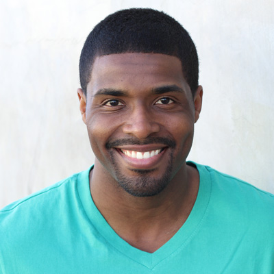 An elderly couple, a man and woman, are smiling together in a candid moment.
